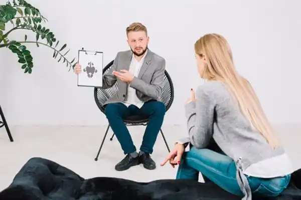 Therapist explaining anxiety management techniques to a client in Indonesia.